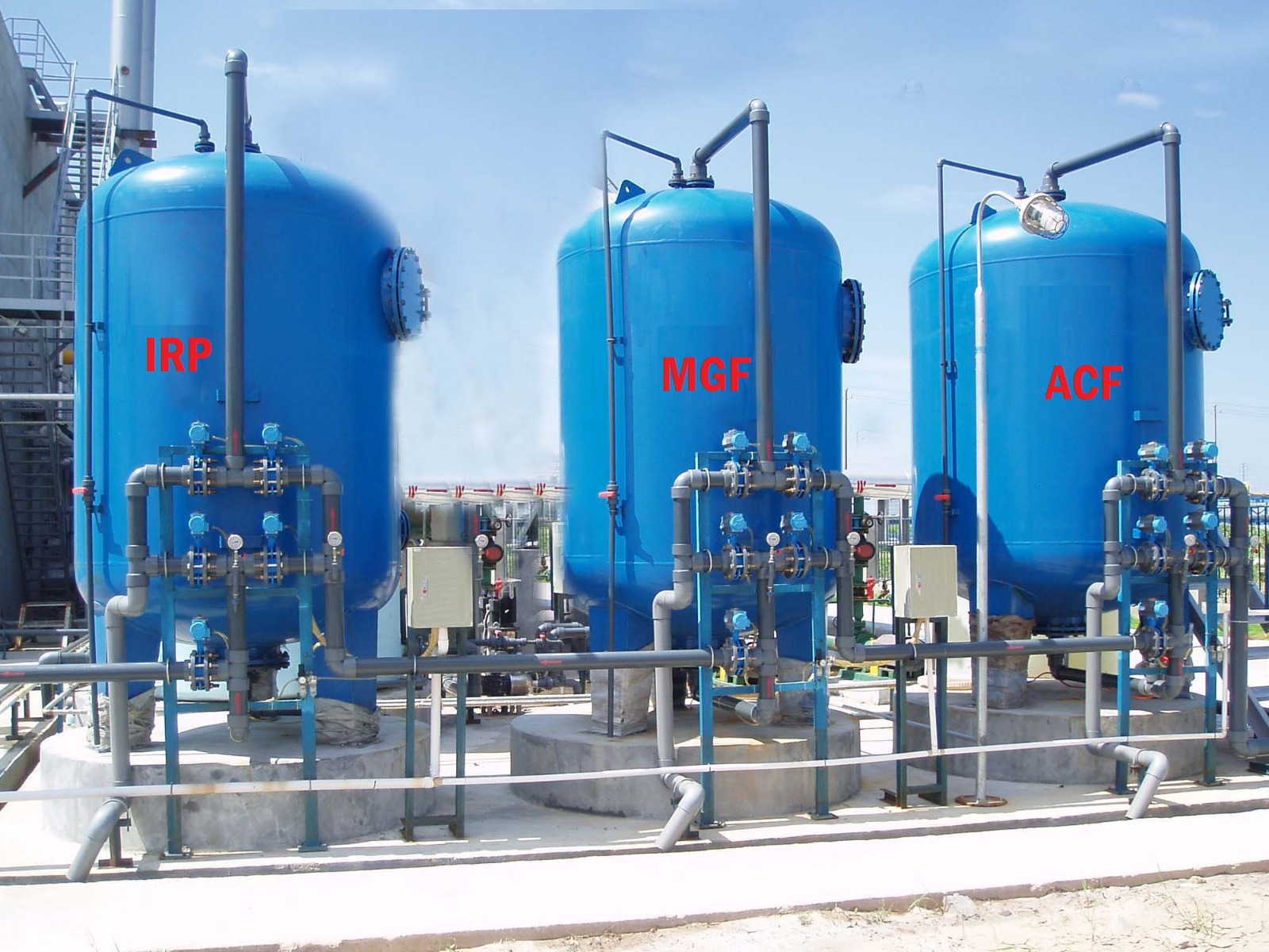 industrial water treatment plant featuring three large blue pressure filtration vessels