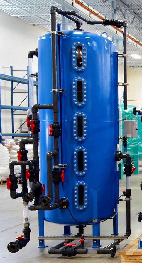 industrial water treatment plant featuring three large blue pressure filtration vessels